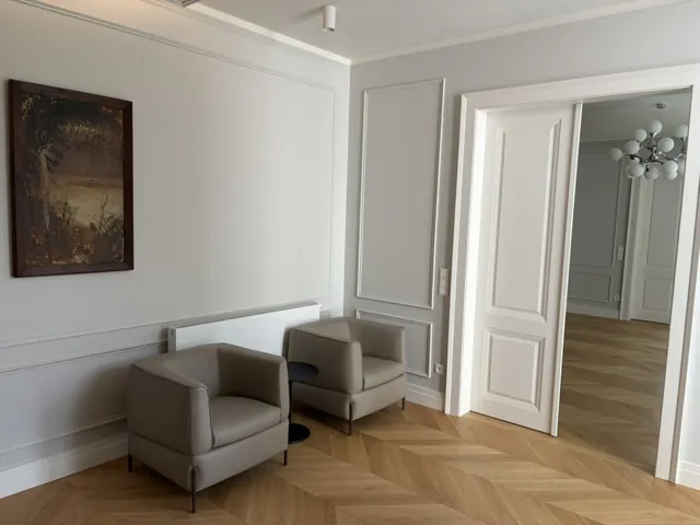 Ozdobné stenové lišty v svetlom interiéri s kreslami